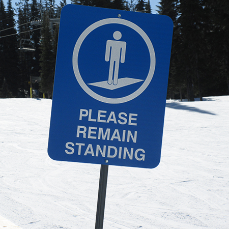 L505 Please Remain Standing with Conveyor Symbol 18" x 24" Blue Reflective Aluminum lift sign for ski areas - produced by Inter-Mtn.. Click to expand image