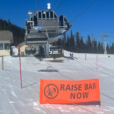 BH49 Raise Bar Now. High-visibility orange banner at the top of Sun Peaks Resort's chairlift in British Columbia. Click to expand image