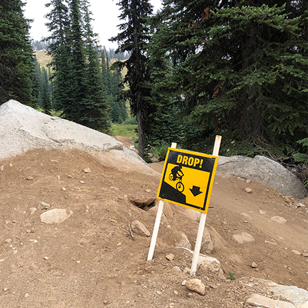 B413, 18 x 18, 12 x 12, drop, arrow pointing down, Mountain bike risk and liability, safety, summer, trail, downhill, available on white or yellow coroplast and 12 gauge sign grade aluminum sheeted with top quality, high performance print* or vinyl graphics.. Click to expand image